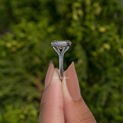 Oval cut half bezel engagement ring shown in side view with slim silver band
