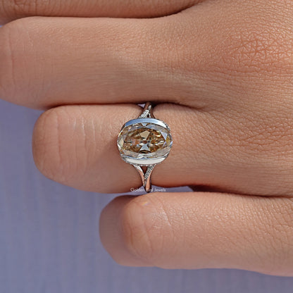 Silver engagement ring with oval-cut center stone and ornate split shank detail