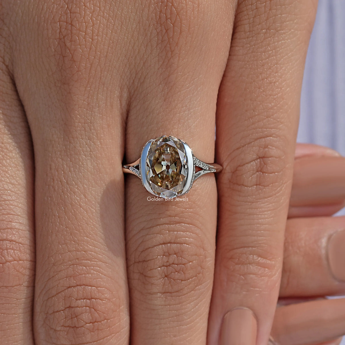 Silver oval-cut engagement ring with split shank and bezel-set center stone
