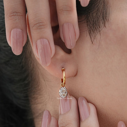 Gold-tone hoop dangle earrings with oval-cut moissanite stone, close-up