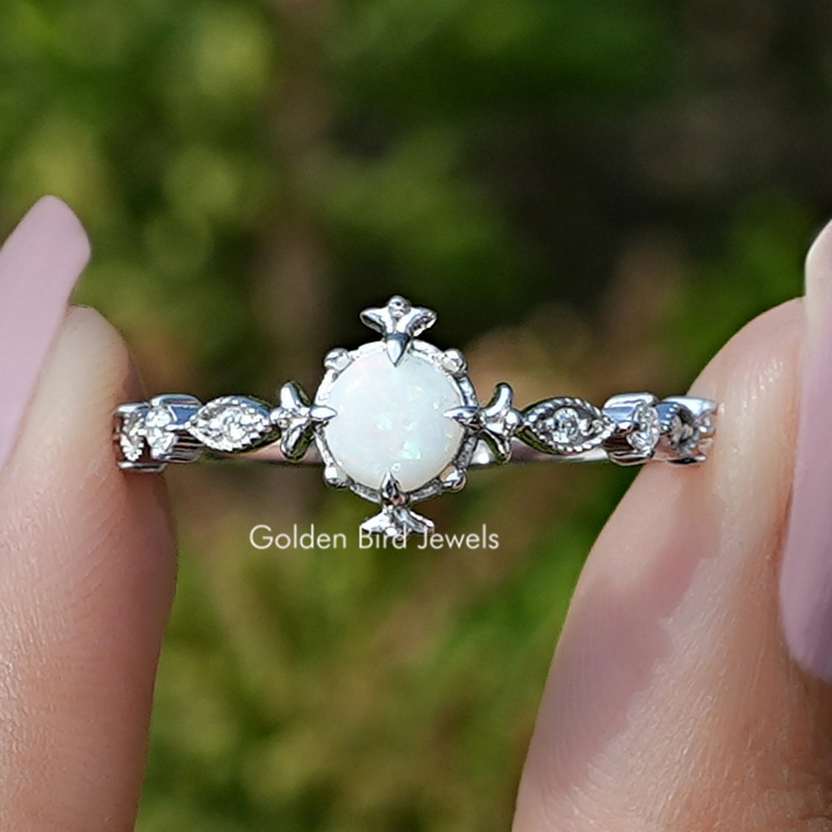 Front view of Opal Round Gemstone Accent Set Engagement Ring Set in two fingers 