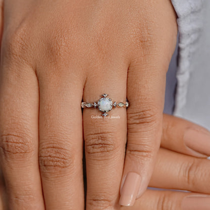 Opal round gemstone accent engagement ring on a hand