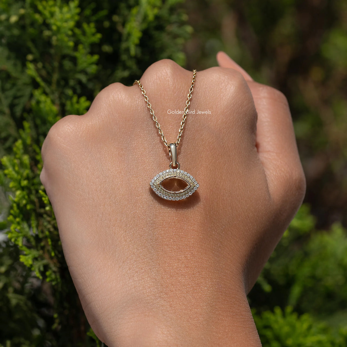 Moissanite open marquise cut pendant on a gold chain, seen on a hand