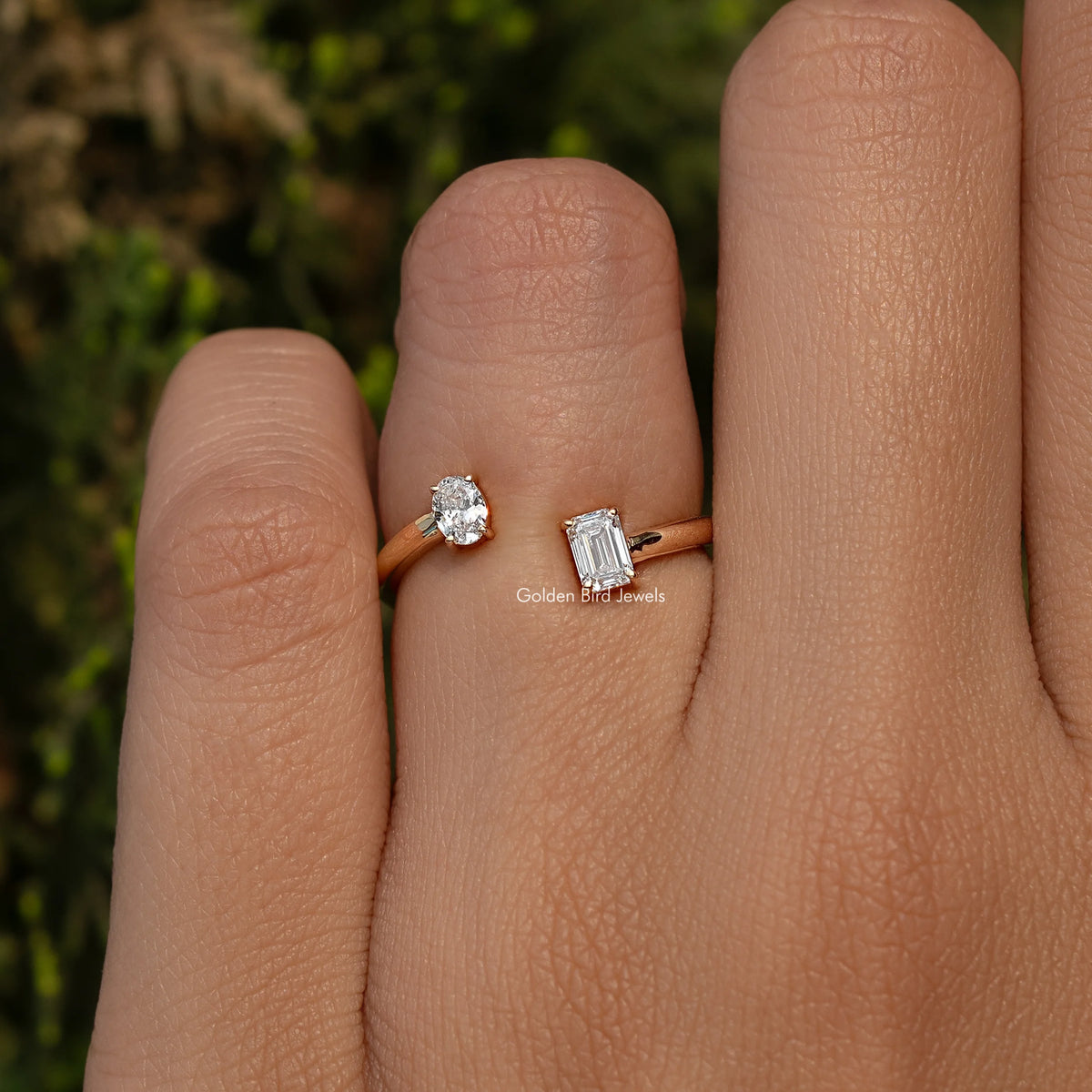 Open cuff lab diamond ring on finger with round and emerald-cut bezels