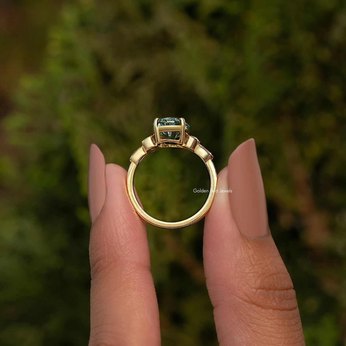 Top view of oval blue-green moissanite proposal ring with prongs and smooth band