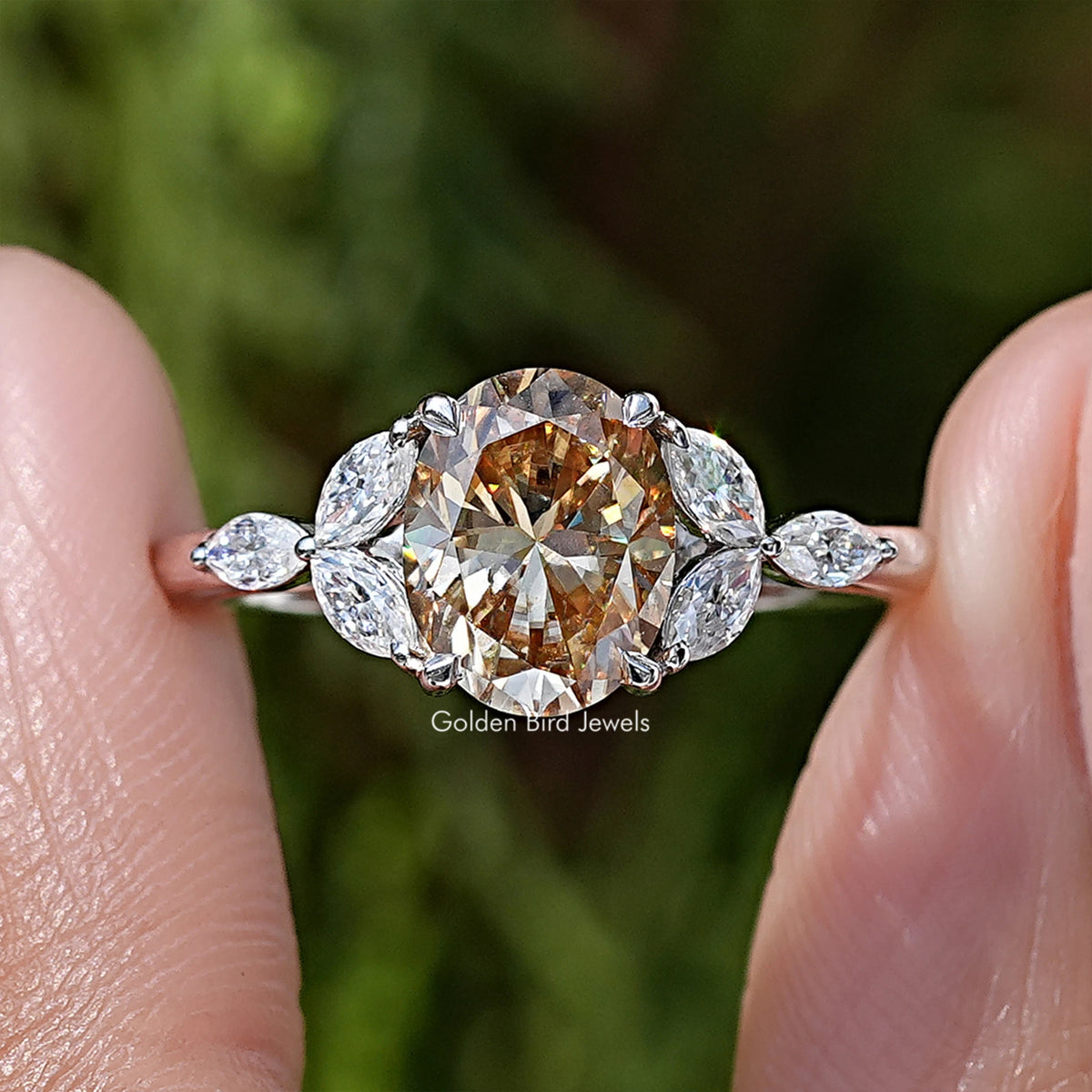 Oval moissanite center with four leaf side stones in sterling silver prong setting