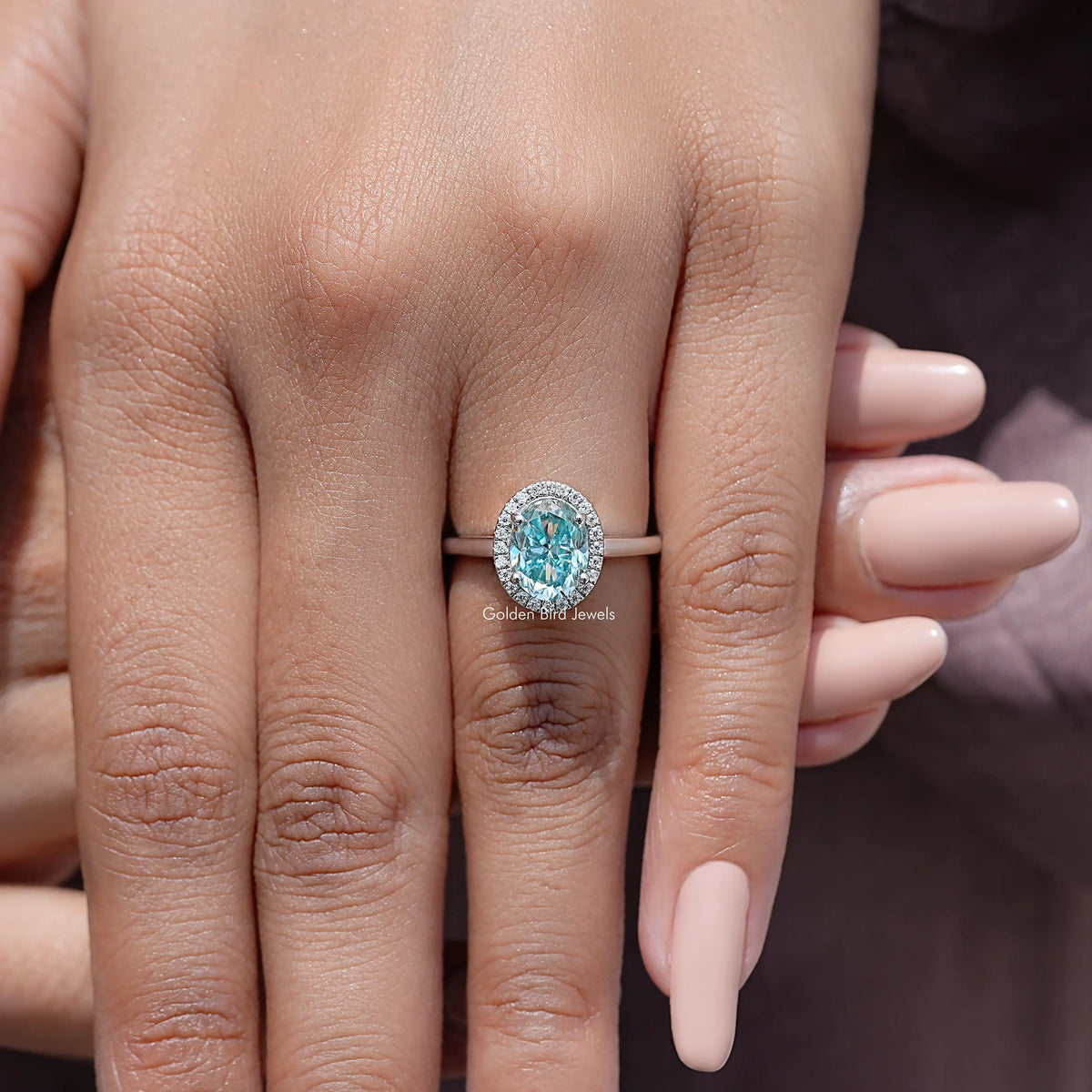 Sterling silver oval moissanite halo ring with blue oval center stone