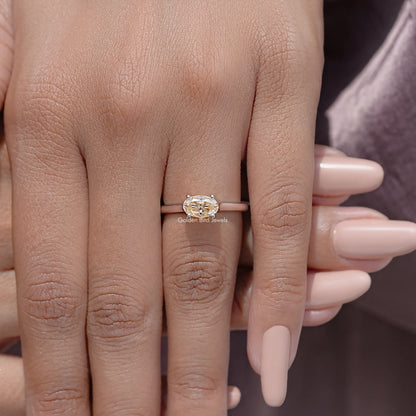 Oval cut moissanite solitaire ring with four-prong setting, slender band.