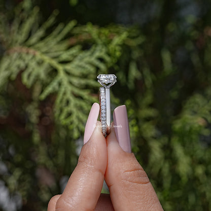 Oval moissanite ring with raised prongs, shown from the top on a fingertip