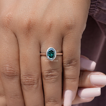 Oval teal moissanite solitaire ring, bezel setting in sterling silver on hand