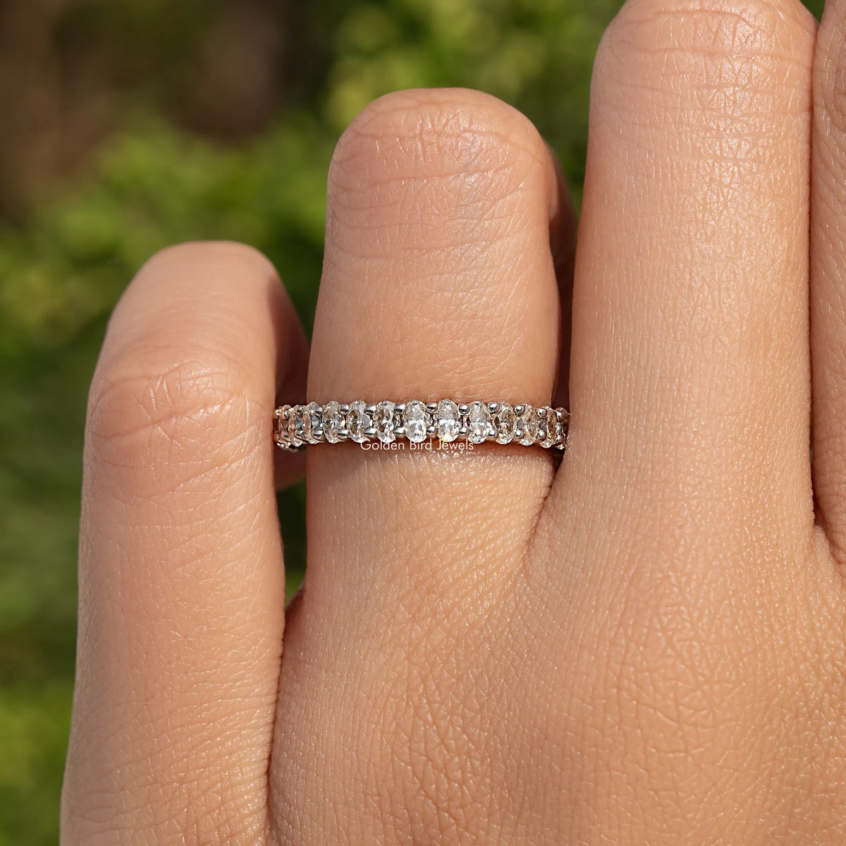 Oval-cut moissanite three-quarter eternity band in 925 sterling silver, on finger