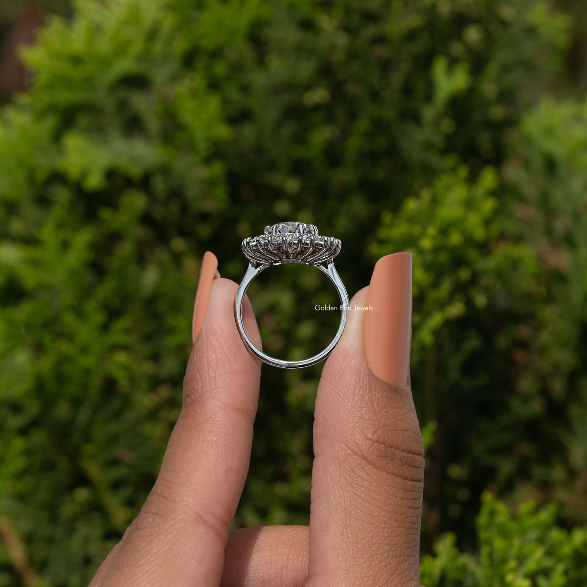 Oval moissanite halo ring in sterling silver, side view of prong-set setting