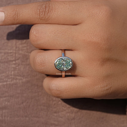Oval moissanite bezel-set solitaire ring close-up on finger
