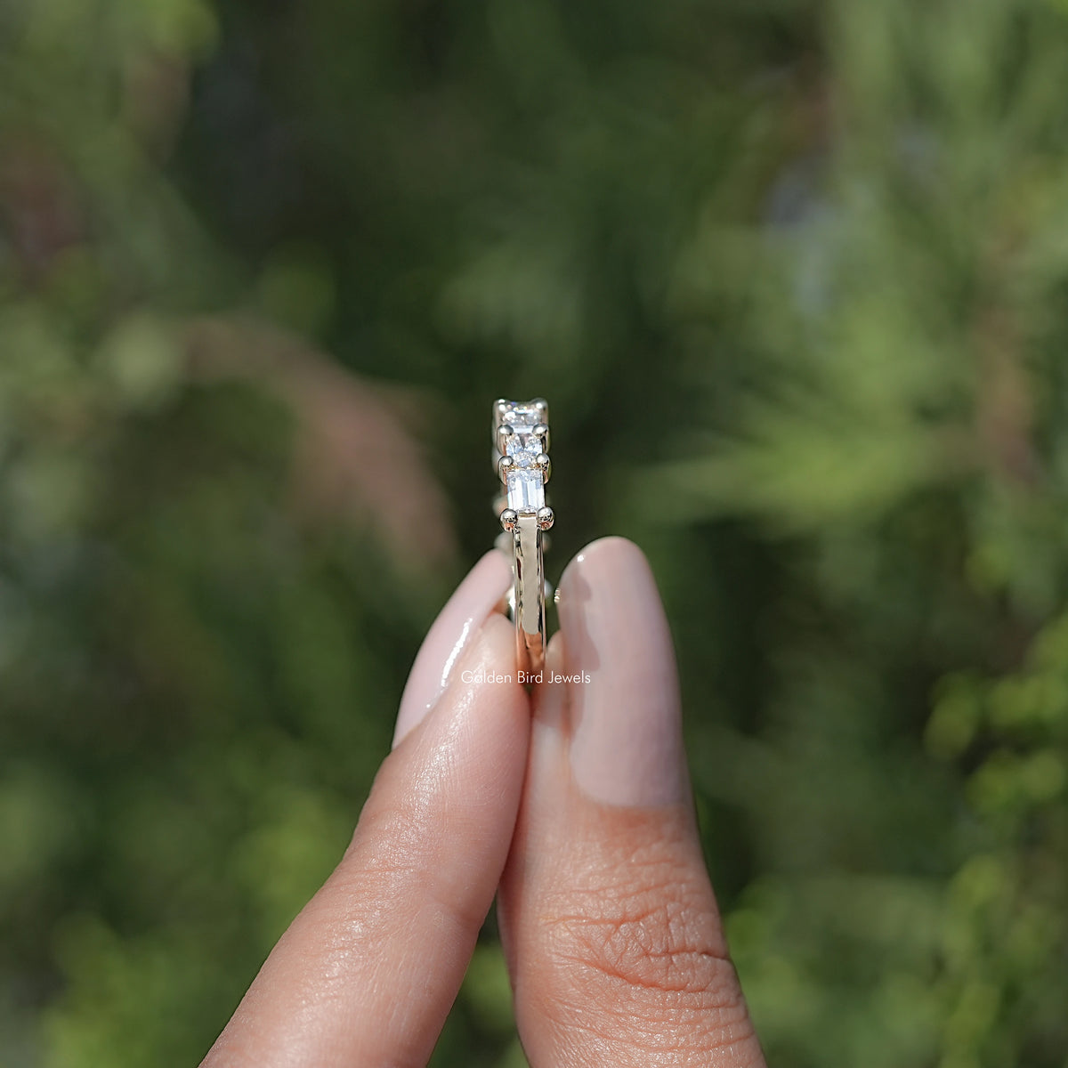 Lab diamond baguette band ring on finger, rectangular stones in gold-toned setting