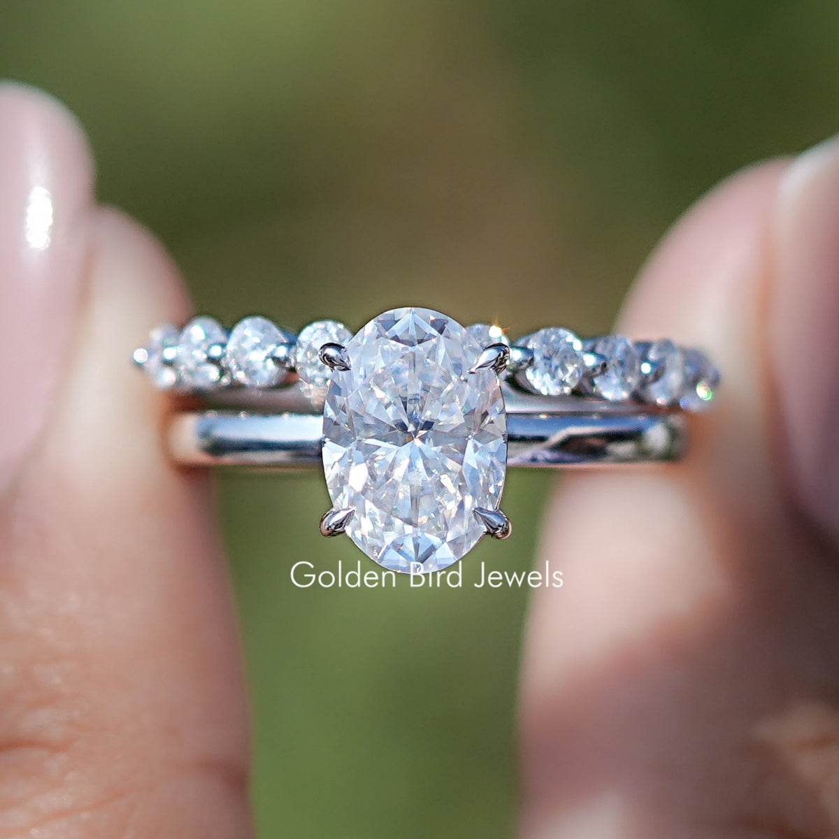 Front view of Oval Cut Moissanite Bridal Ring With Eternity Band in two fingers 