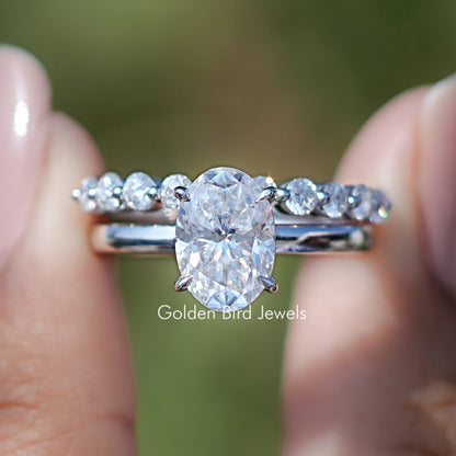 Front view of Oval Cut Moissanite Bridal Ring With Eternity Band in two fingers 