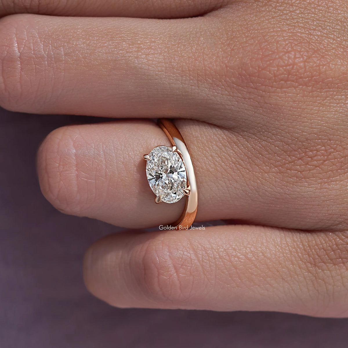Oval solitaire ring with rose-gold band; close view of oval center diamond