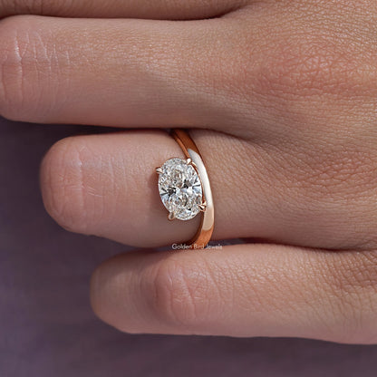 Oval solitaire ring with rose-gold band; close view of oval center diamond
