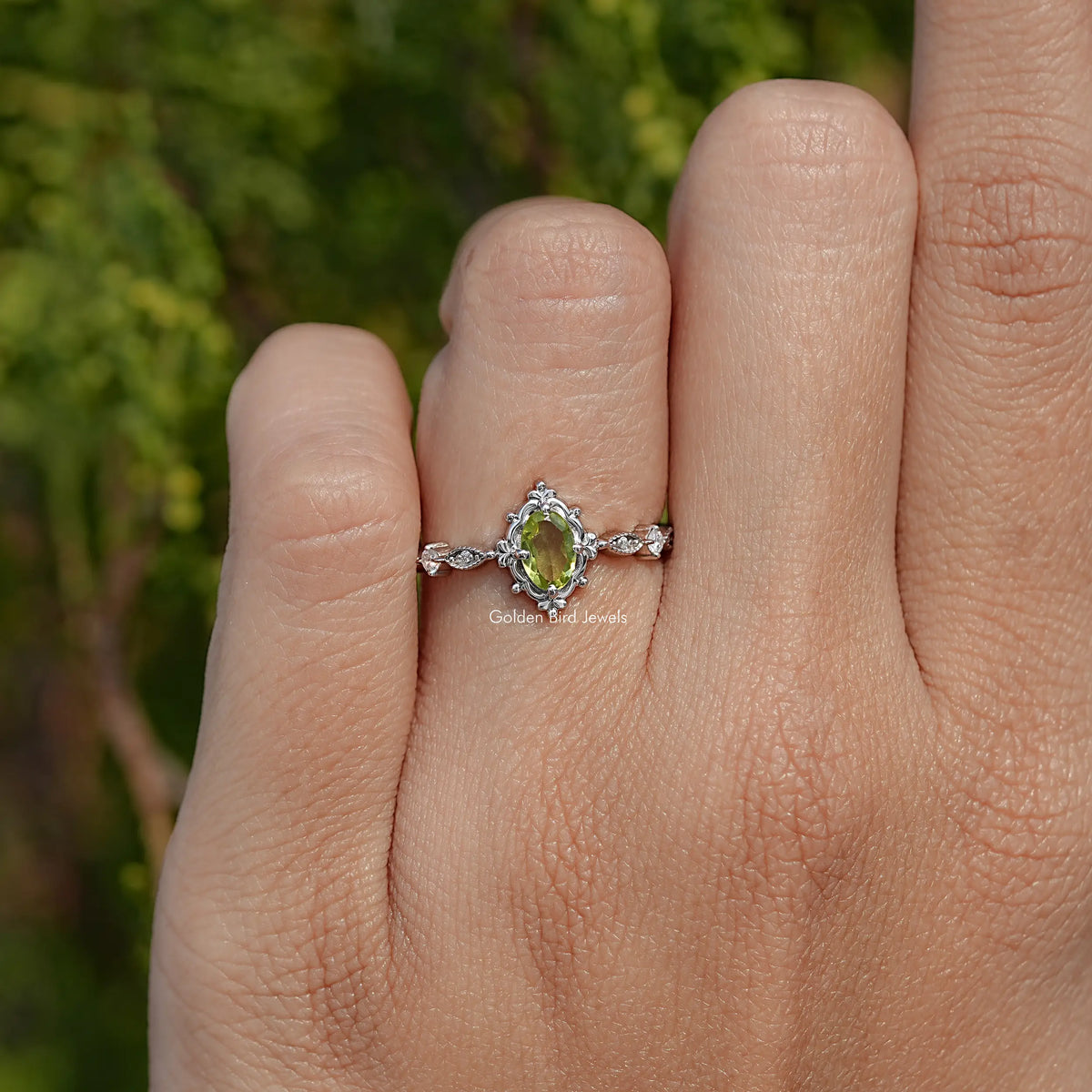 Peridot green oval-cut gemstone accent ring with floral details