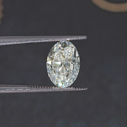 Oval-cut moissanite loose stone, faceted oval held in silver prongs