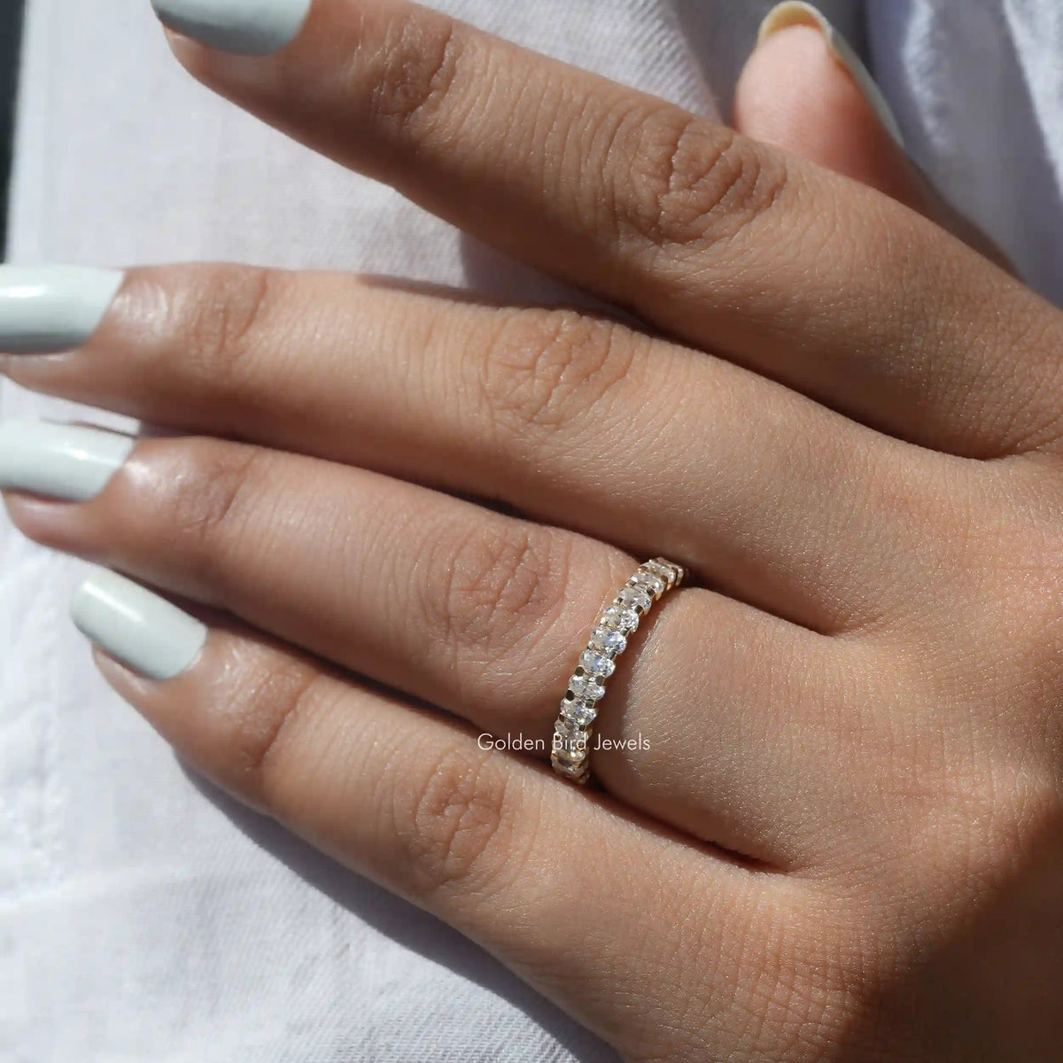 [In finger front view of oval cut moissanite wedding band]-[Golden Bird Jewels]