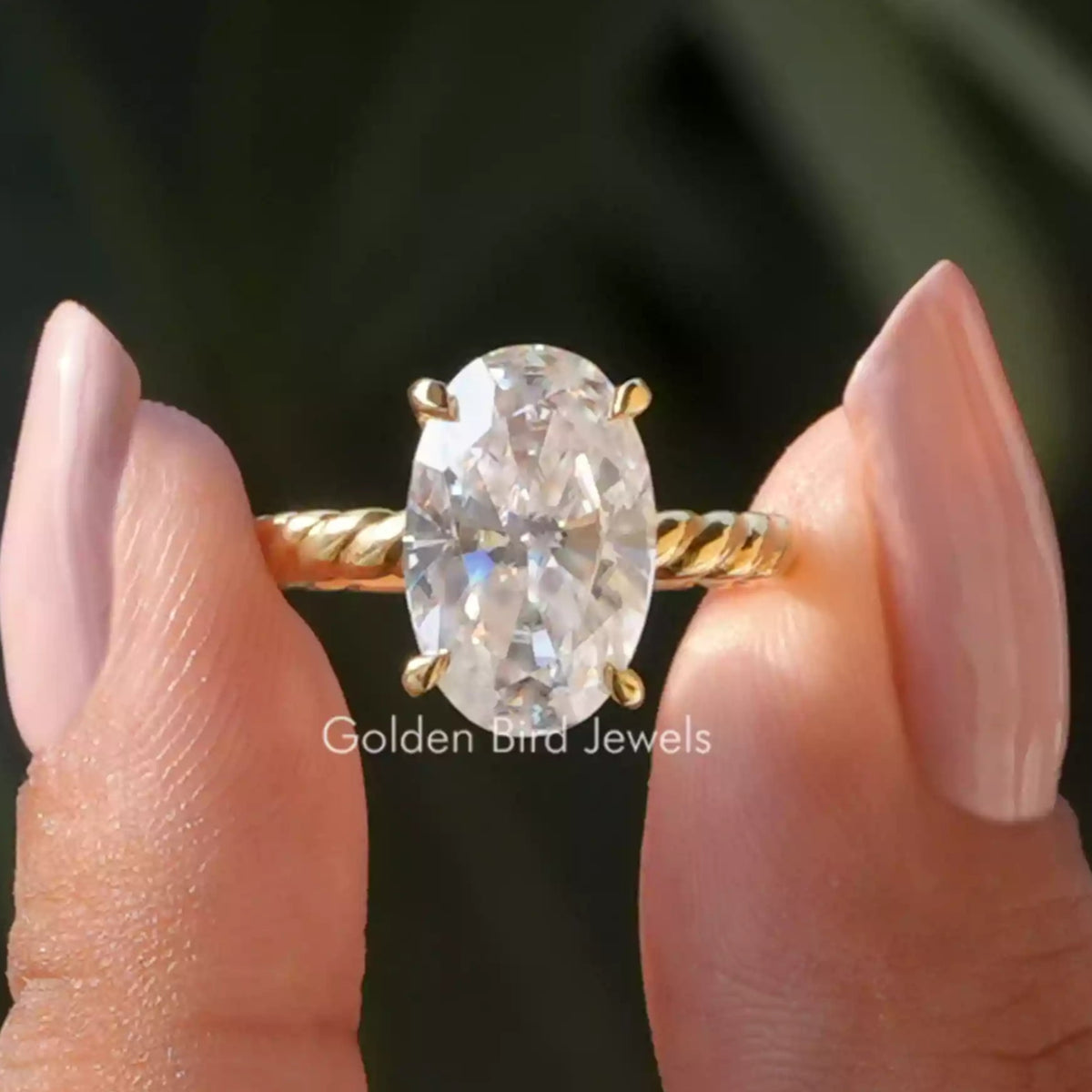 Oval-cut moissanite solitaire ring with gold-tone band and 4-prong setting