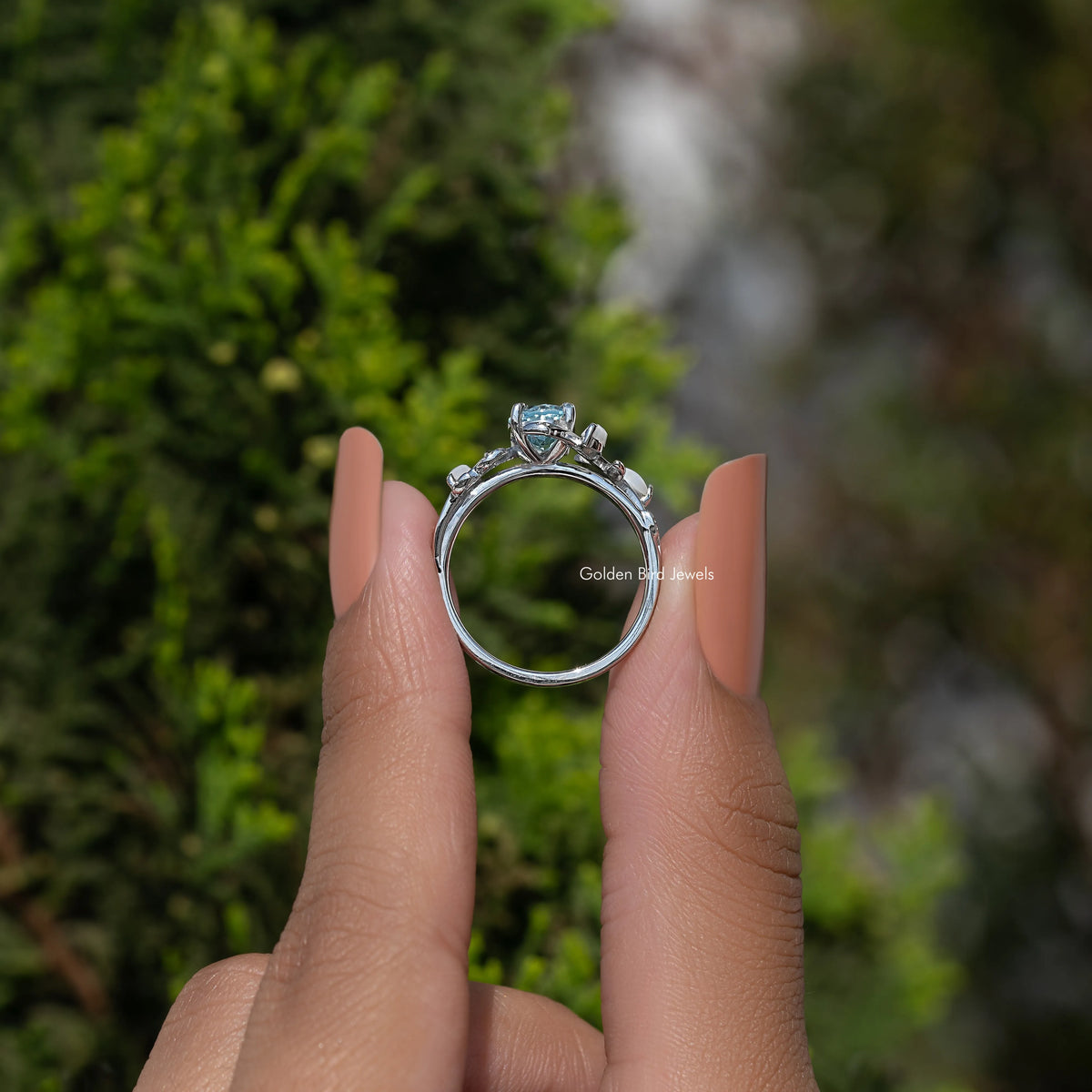 Argentium silver ring with oval blue center stone and leaf-style bypass setting