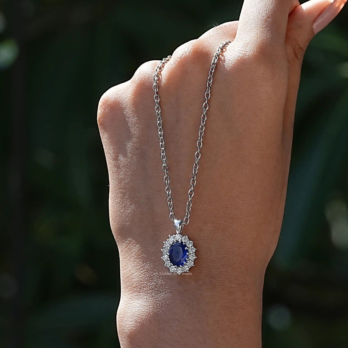 In hand showing view of diamond pendant	