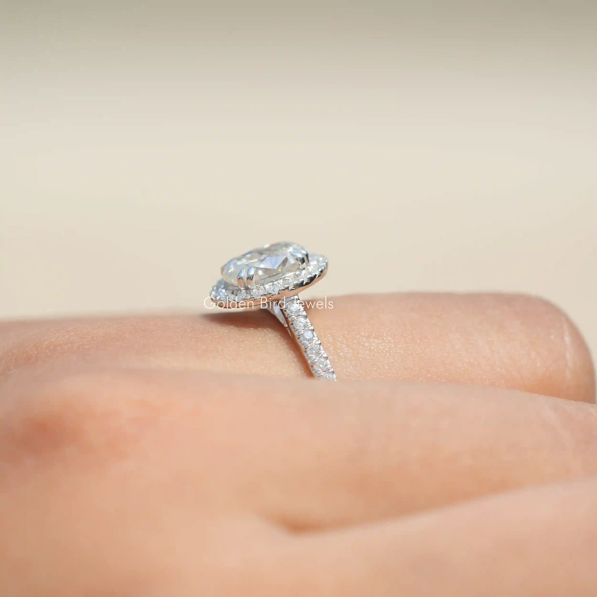 Oval moissanite halo accent ring on finger