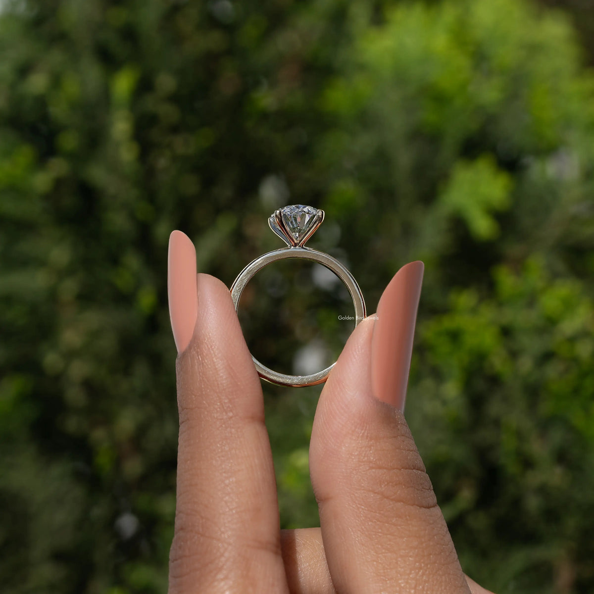 Oval lab diamond solitaire ring, gold band with round four-prong bezel from side view