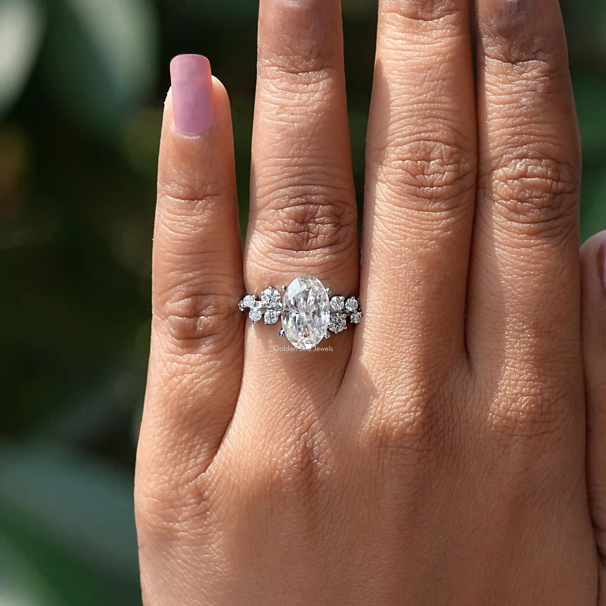 In finger view of oval shaped ring crafted with white side stones 