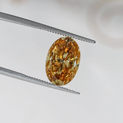 Oval champagne moissanite loose stone in tweezers, warm honey-gold sparkle