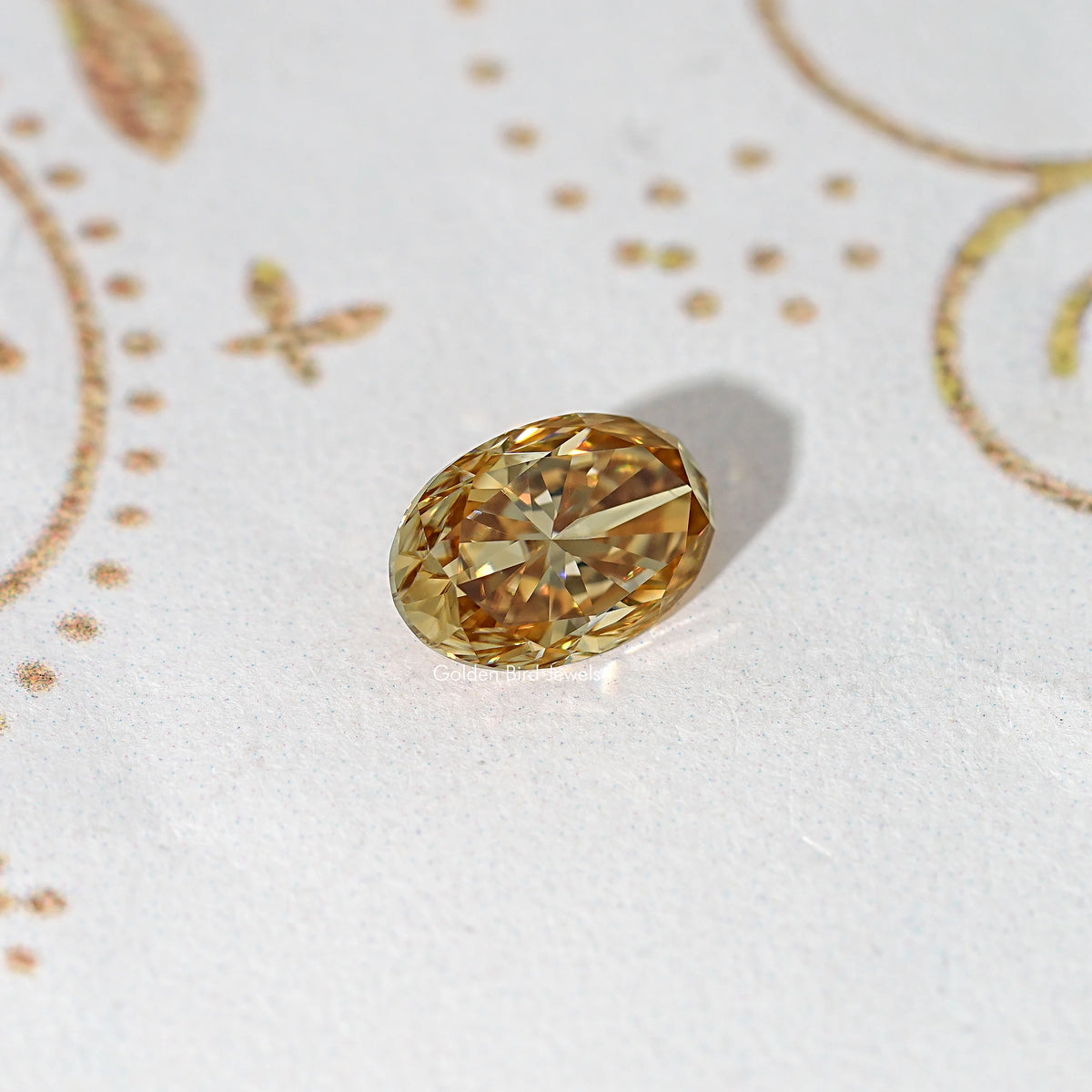 Champagne oval moissanite loose stone on a light background, faceted gold