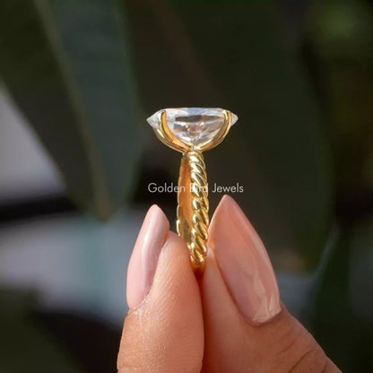 Oval-cut moissanite solitaire ring, side view of gold-tone band with 4-prong setting