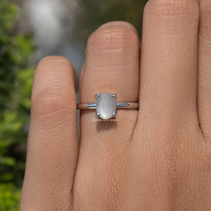 Oval moonstone solitaire ring, 935 Argentium silver, small four-prong oval stone detail on finger