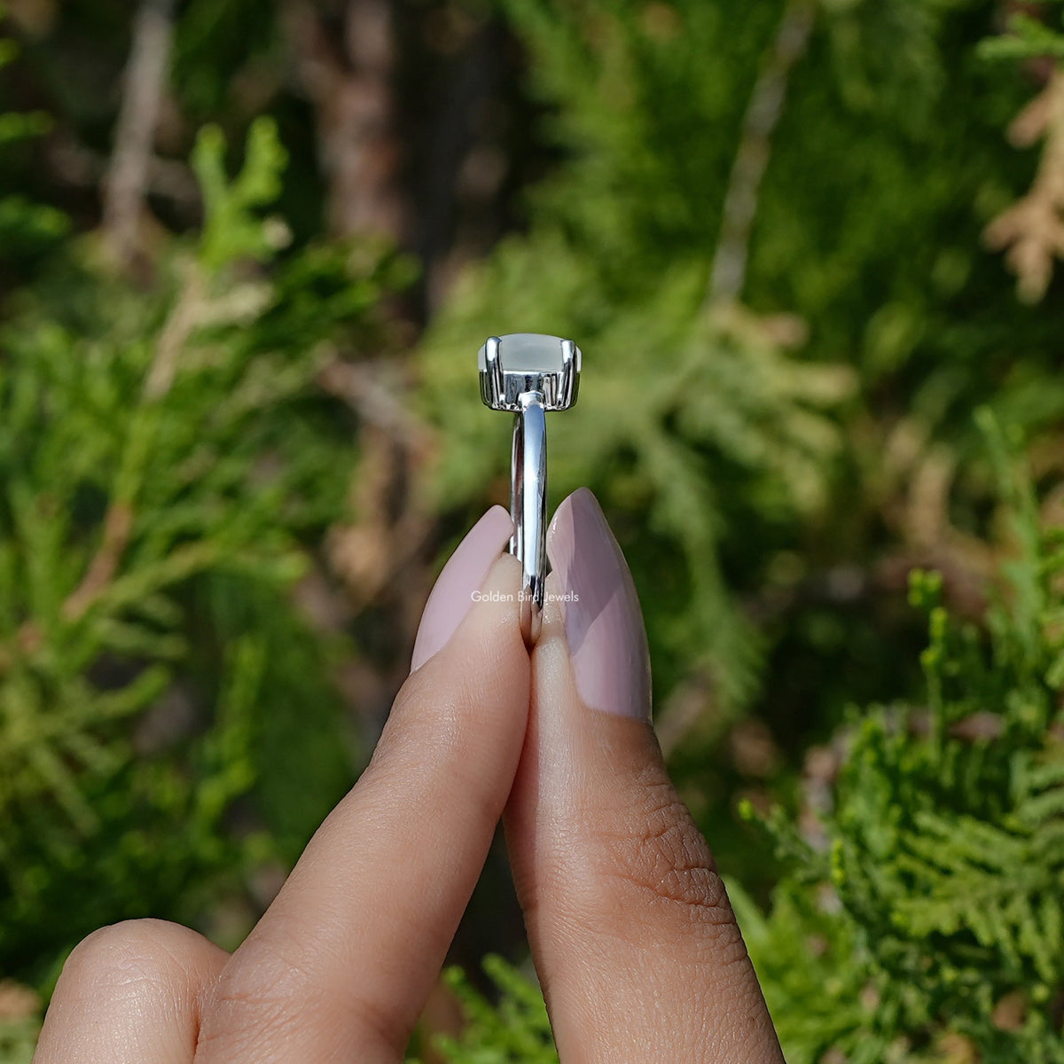 Oval moonstone solitaire ring with square prong setting on sterling silver band