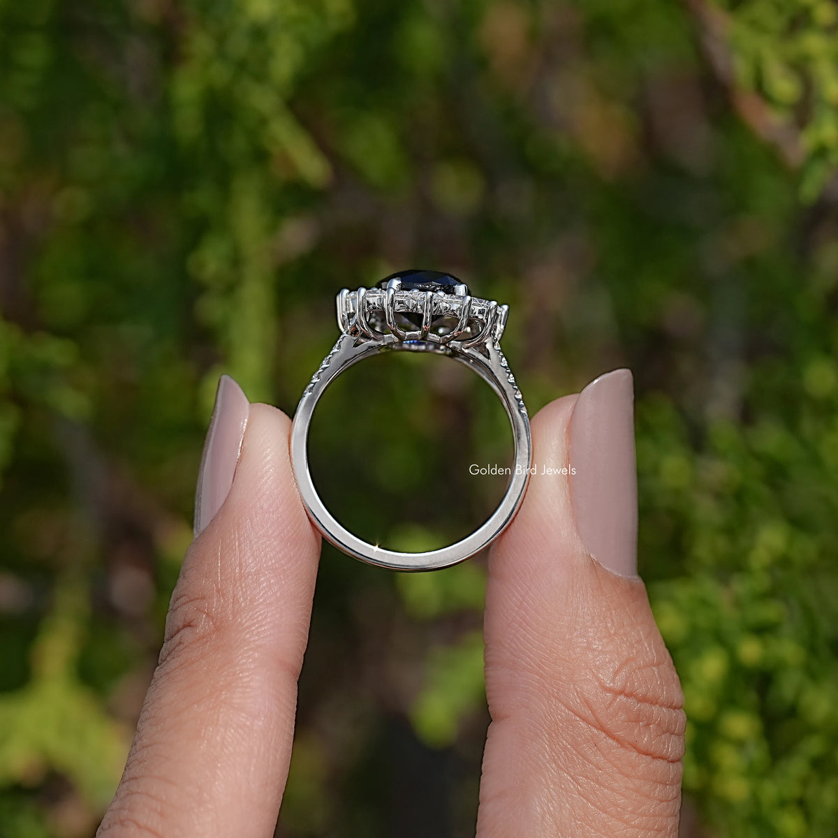 Oval dark sapphire halo ring with split shank, silver-toned setting