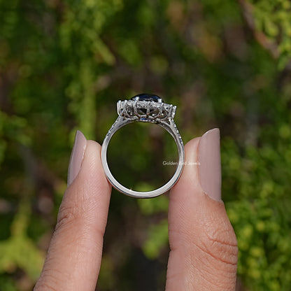 Oval dark sapphire halo ring with split shank, silver-toned setting
