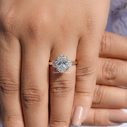 Three-stone diamond engagement ring with center stone and side stones, on fingers