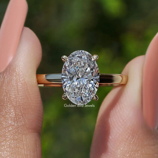 Oval lab diamond solitaire engagement ring with gold band and four-prong setting