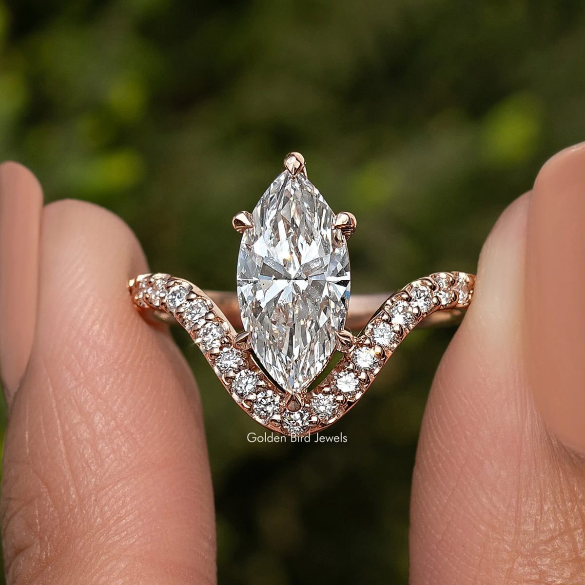 Gold-tone marquise-cut diamond ring with curved three-stone side accents