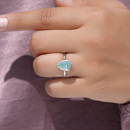 Sterling silver pear-cut moissanite bezel solitaire ring, close on fingers