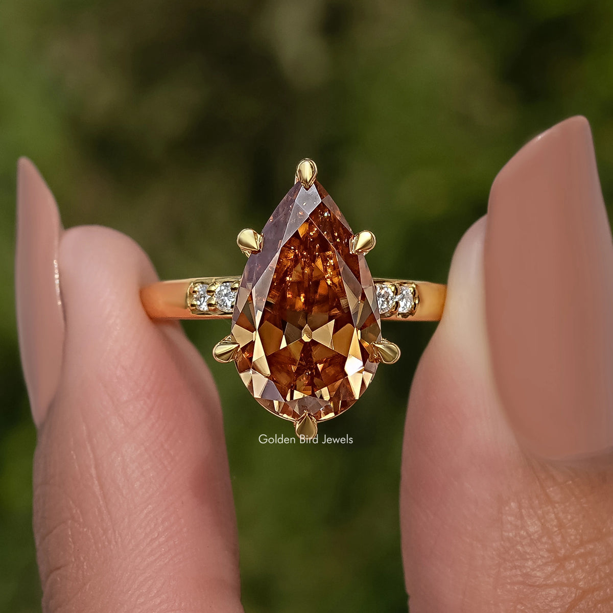 Gold pear-cut engagement ring with marquise accents and bright side stones