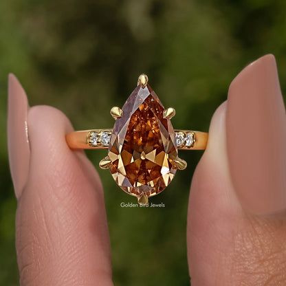 Gold pear-cut engagement ring with marquise accents and bright side stones
