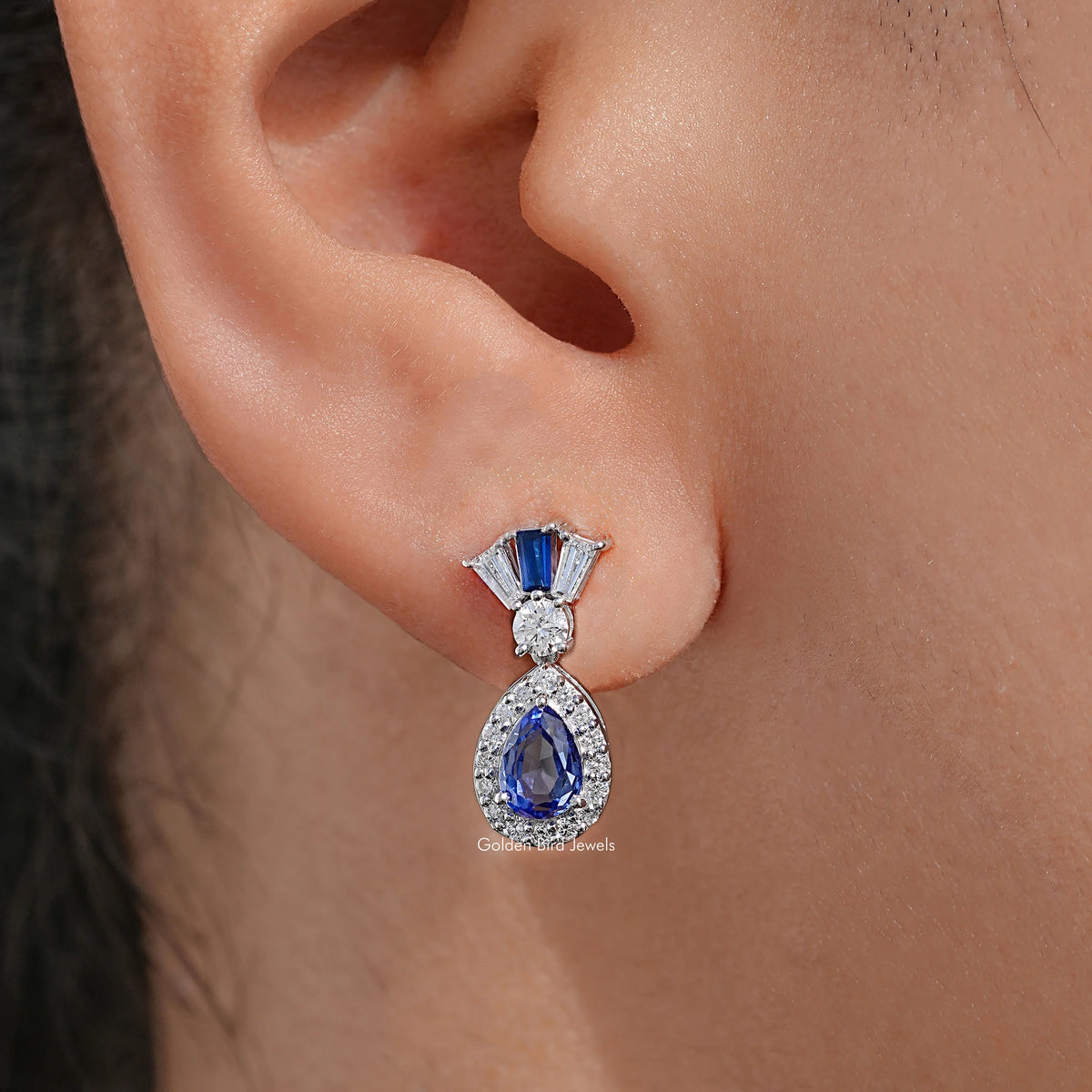 Blue pear-cut drop earrings with diamond halo and baguette top, silver-tone finish
