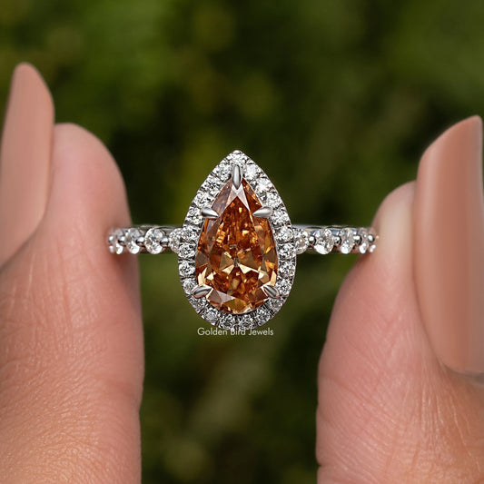 Pear-cut halo engagement ring with amber center stone and silver band