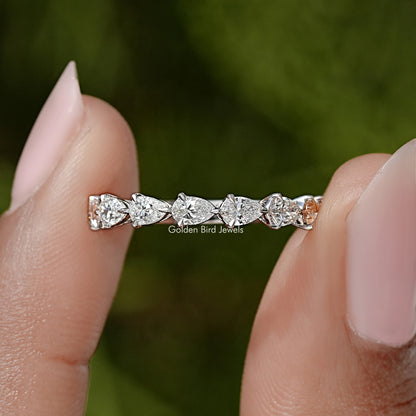 Pear-cut diamond eternity band with prong-set stones on a slim silver ring