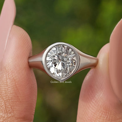 Silver bezel-set diamond engagement ring, front close-up on finger