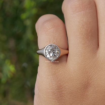 Pear-cut diamond bezel-set engagement ring in silver, profile view on finger