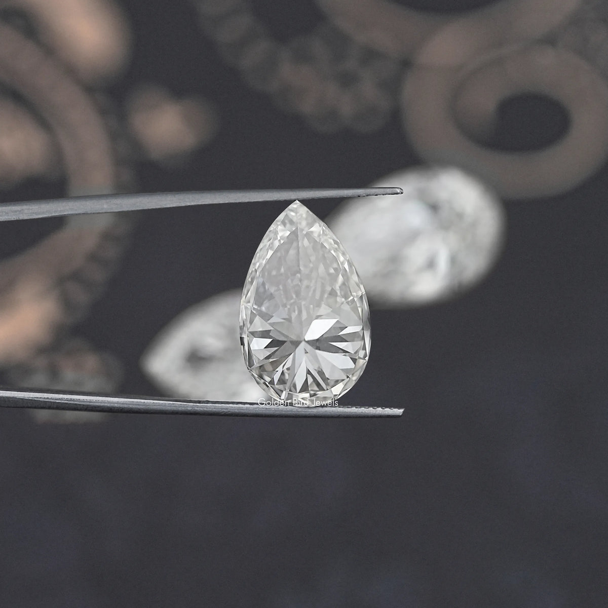 Pear-cut loose lab diamond on prongs, angled view showing faceted pavilion